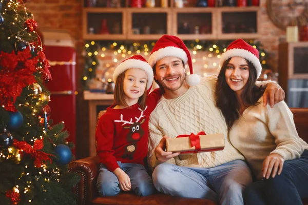 Любляча сім'я позує з різдвяними подарунками на прикрашеному домашньому тлі — стокове фото