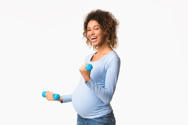 Preto mulher grávida exercendo com halteres, fundo branco — Fotografia de Stock