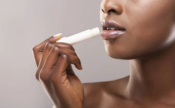 Afričanky americká žena nanášení hygienické rty balzám — Stock fotografie