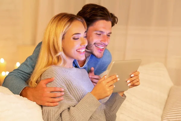 Manželé sledování filmu na tabletu sedí na gauči doma — Stock fotografie