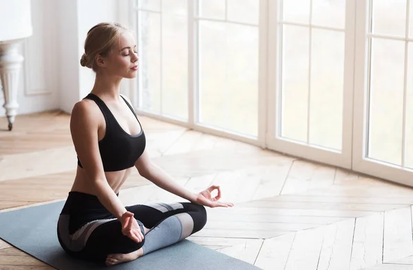 Ragazza di yoga con gli occhi chiusi seduto in posa di loto — Foto Stock