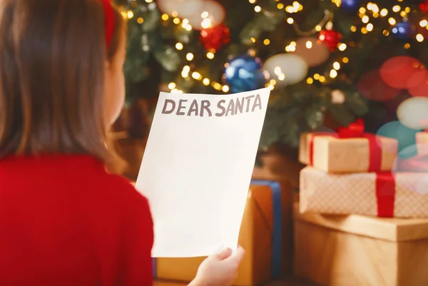 Vista posterior de la niña sosteniendo carta a Santa —  Fotos de Stock
