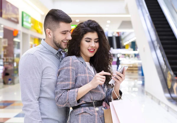 Shoppingapp. Par som använder mobiltelefon söka rabatterbjudanden — Stockfoto