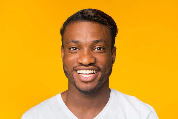 Retrato de negro sonriendo parado sobre fondo amarillo — Foto de Stock