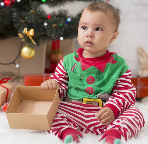 Upset toddler opening empty box without gift in new years eve