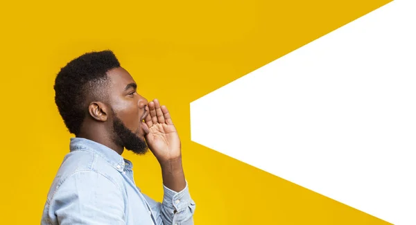 Guy making loud announcement at copy space on yellow background — Stock Photo, Image