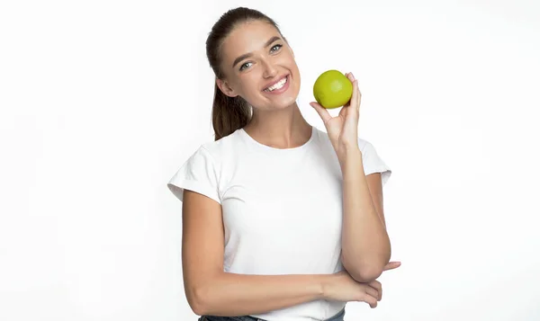 Mujer sosteniendo manzana sonriendo posando sobre fondo blanco — Foto de Stock
