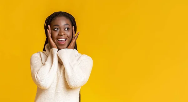 Erstaunt Afro-Girl berührt ihre Wangen, Blick auf Kopierraum — Stockfoto