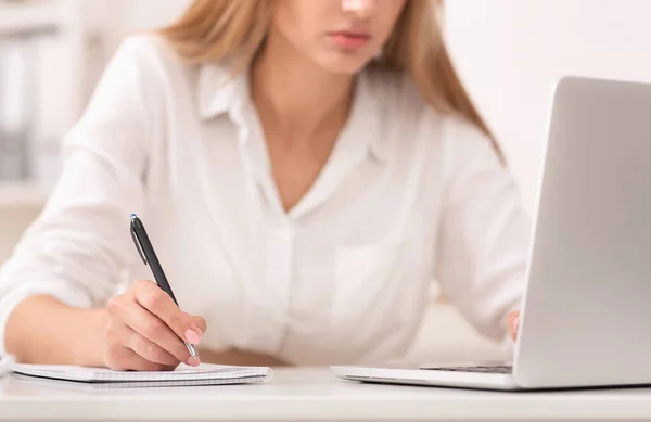 Empresária irreconhecível tomando notas sentado no escritório moderno, cortado — Fotografia de Stock