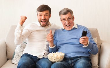 Yaşlı bir adam ve yaşlı bir baba televizyonda maç izliyor.