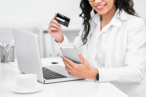 Happy woman with credit card and mobile phone