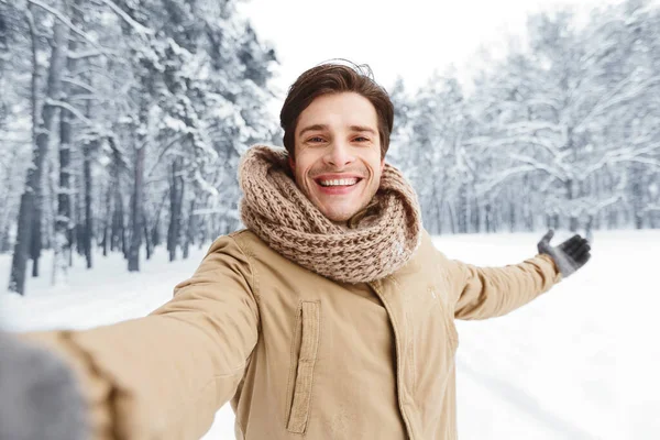 Hombre feliz tomando selfie de pie en el bosque de invierno —  Fotos de Stock
