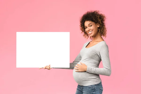Černá těhotná žena ukazující prázdné reklamní prkno — Stock fotografie