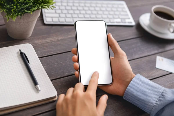 Hombre irreconocible usando un teléfono inteligente moderno con pantalla en blanco en el lugar de trabajo — Foto de Stock
