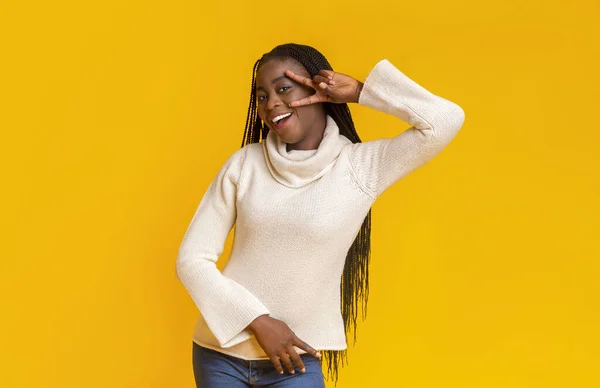 Joyful jovem mulher negra flertando sobre fundo amarelo — Fotografia de Stock