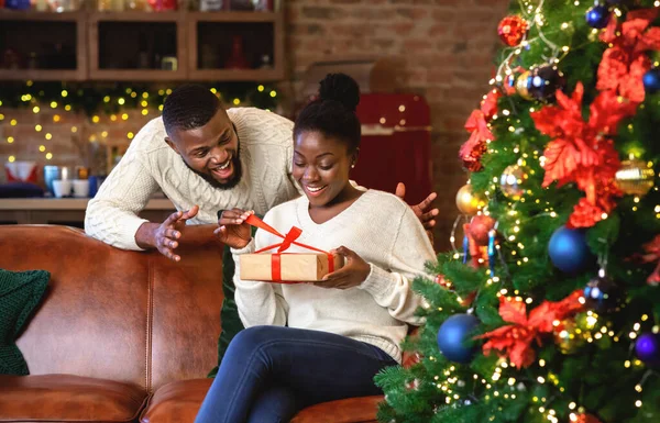 Heyecanlı siyah eş kocasının Noel hediyesini açıyor. — Stok fotoğraf