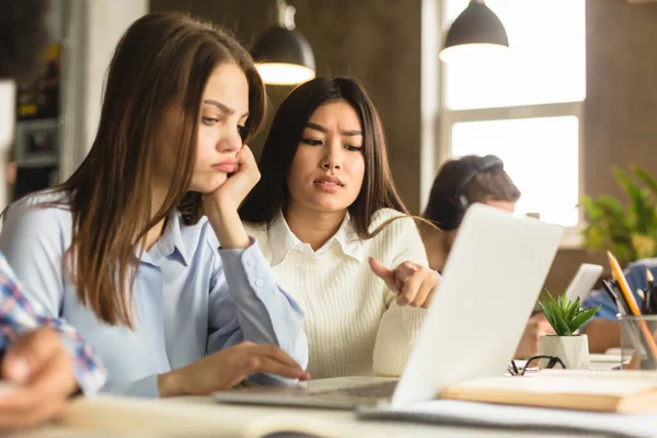 E-learningu. Studentki korzystające z laptopa w bibliotece — Zdjęcie stockowe