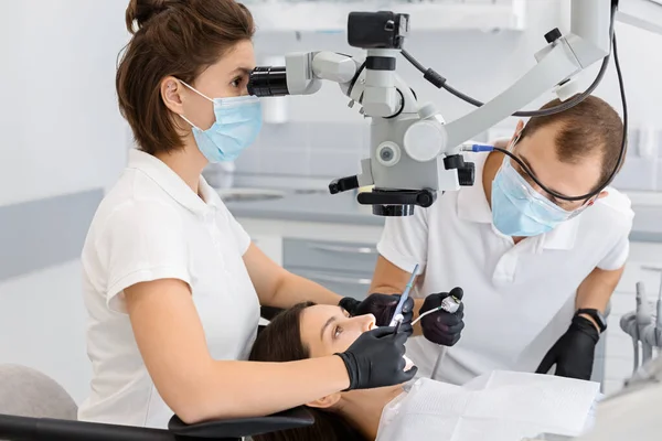 Geschoolde vrouwelijke tandarts maken chirurgie in tandheelkundige kantoor — Stockfoto