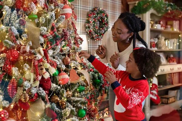 Adorável menina afro decorando árvore de Natal com sua mãe — Fotografia de Stock