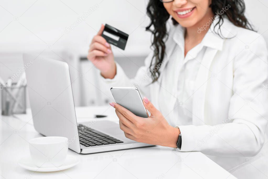 Happy woman with credit card and mobile phone
