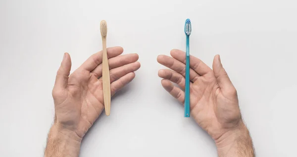 Händer med två tandborstar på vit bakgrund — Stockfoto