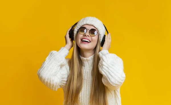 Vinterflicka skrattar av glädje, lyssnar på musik — Stockfoto