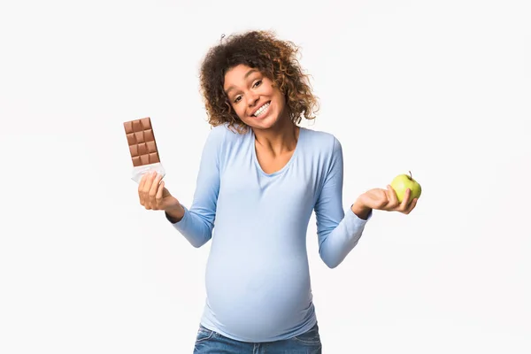 妊娠食。リンゴとチョコレートを選ぶ妊婦 — ストック写真