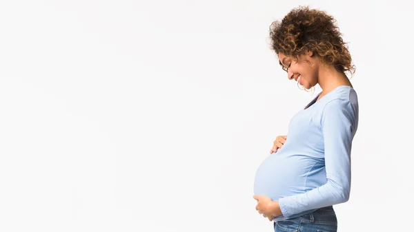 Απολαμβάνω τη μητρότητα. Άφρο έγκυος γυναίκα αγκαλιάζει την κοιλιά της — Φωτογραφία Αρχείου
