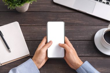 İş yerinde boş ekranlı akıllı telefon kullanan tanınmayan bir adam