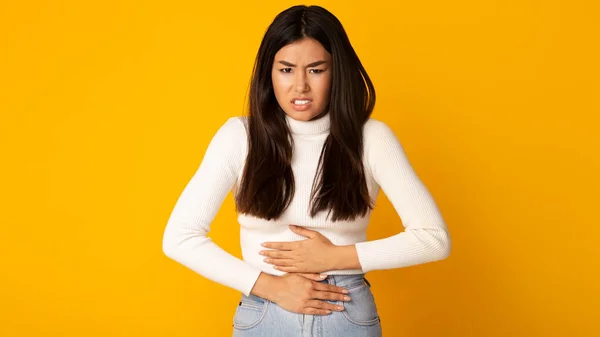 Asiática chica con dolor de estómago teniendo intoxicación alimentaria —  Fotos de Stock