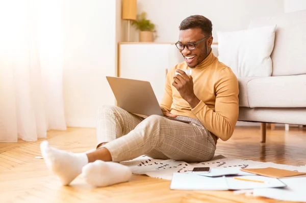 Gelukkig freelancer man werken aan laptop drinken koffie thuis — Stockfoto