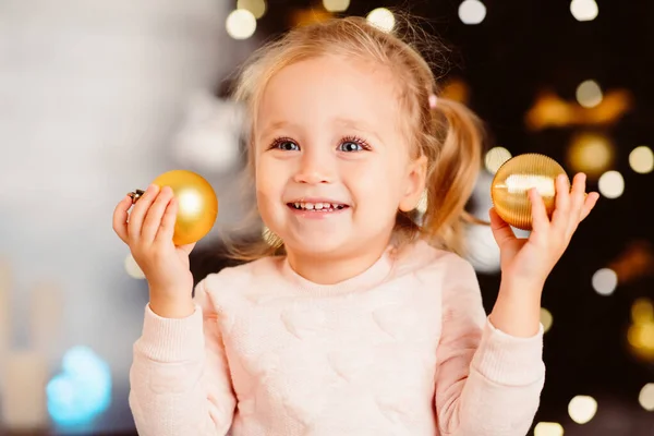 Niño pequeño con bolas de Navidad disfrutando de vacaciones de invierno —  Fotos de Stock