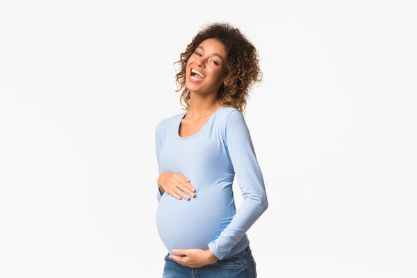 Emocionada mujer embarazada afroamericana tocando el vientre y riendo —  Fotos de Stock