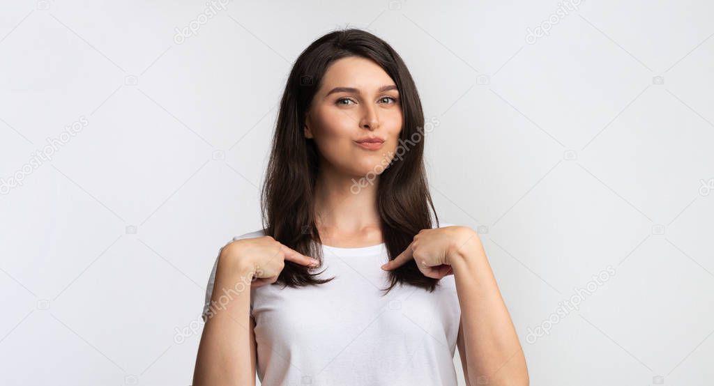 Smiling Girl Standing Pointing Fingers At Herself, Studio Shot, Panorama
