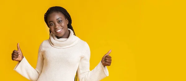 Молодая улыбающаяся афро-девушка поднимает большие пальцы вверх — стоковое фото