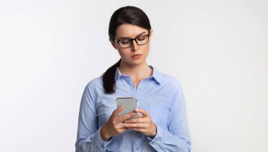 Ciddi İş Kadını Stüdyoda Akıllı Telefon Mesajlaşması Kullanıyor