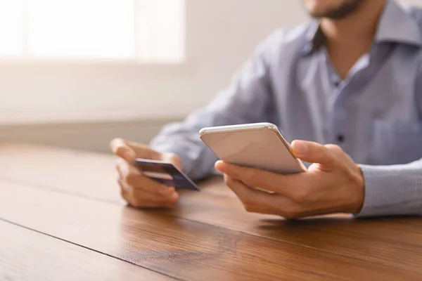 Beskuren bild av människan med kreditkort och modern smartphone — Stockfoto