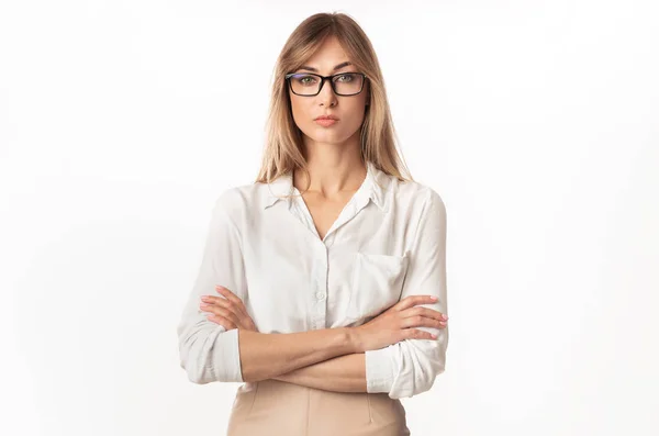 Serieuze zakenvrouw staande kruisen handen op witte studio achtergrond — Stockfoto