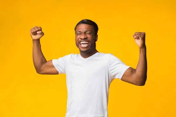 Emotionele Afro Man Schreeuwen schudden vuisten staande op gele achtergrond — Stockfoto