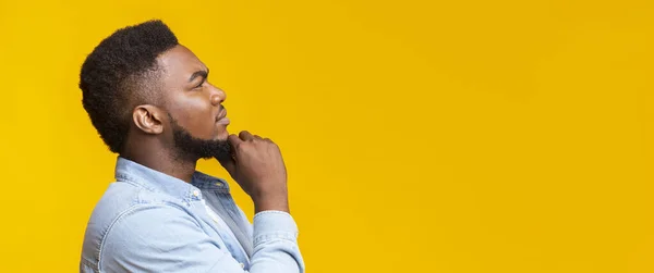 Thoughtful african man touching his beard and looking at copy space — Stock Photo, Image