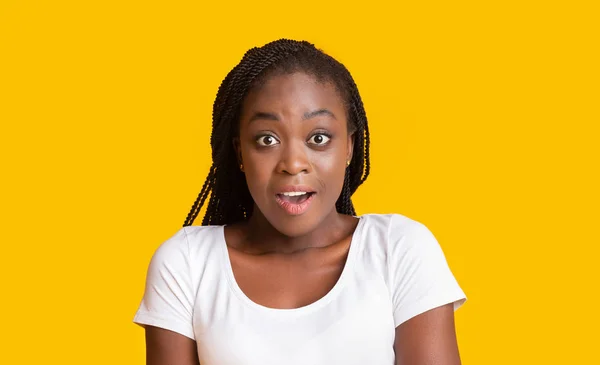Sarı arka planda şok olmuş Afrikalı bir kızın portresi — Stok fotoğraf