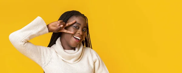 Портрет игривой афро-девушки, позирующей на жёлтом фоне — стоковое фото