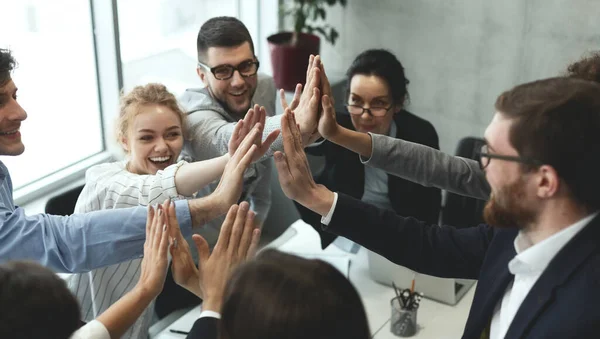 Colleagues Giving High-Five Celebrating Business Success Standing In Office  Stock Photo by ©Milkos 381522740