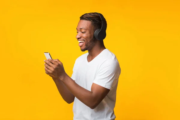 Black Guy In Headphones Standing Using Mobile Phone, Studio Shot — ストック写真