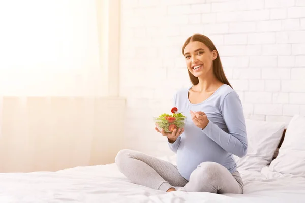 Positive Pregnant Woman Eating Salad Sitting On Bed Indoor — Stock Photo, Image