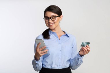 Gülümseyen İş Kadını Telefon ve Kredi Kartını Beyaz Arkaplan Üzerinde Kullanıyor