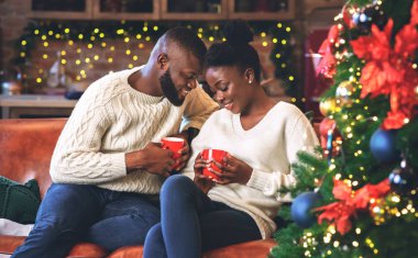 Siyah çift Noel 'i birlikte kutluyor, eğlence için kahve falı bakıyorlar.