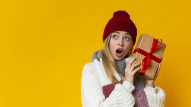 Yeni yıl hediyesiyle şaşırmış bir kız fotokopi odasına bakıyor.
