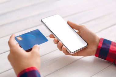 Çevrimiçi alışveriş için akıllı telefon ve kredi kartı kullanan tanınmayan bir adam