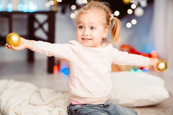 Niña alegre jugando con decoraciones de árboles de Navidad —  Fotos de Stock